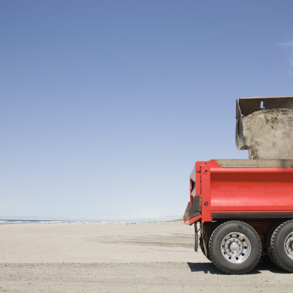 54657,Truck shoveling sand on beach